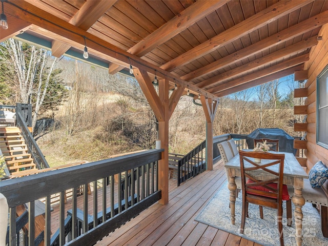 wooden terrace with stairway and outdoor dining area