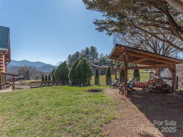 view of yard featuring fence, a fire pit, and a mountain view