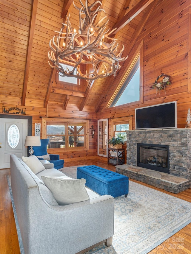living area featuring wood walls, beamed ceiling, and high vaulted ceiling