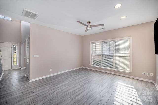 unfurnished room featuring wood finished floors, visible vents, and baseboards