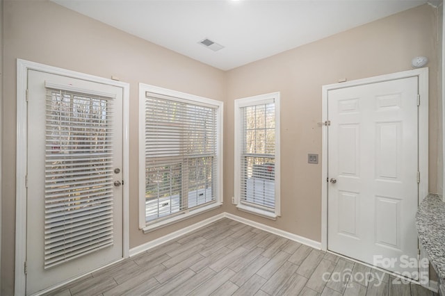 foyer with baseboards, visible vents, and light wood finished floors