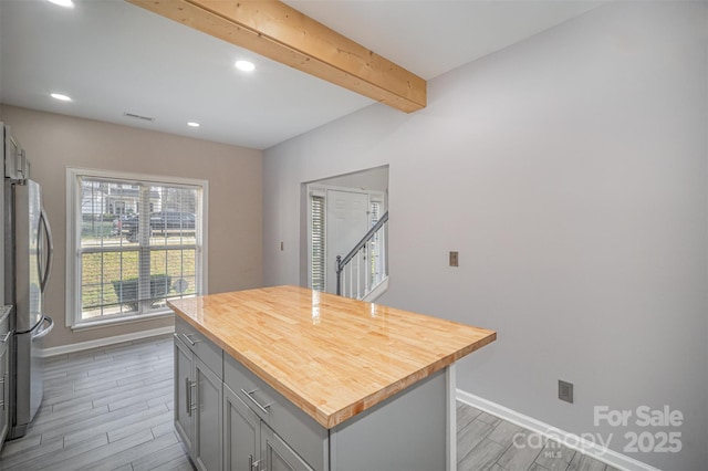 kitchen featuring wood finish floors, wooden counters, gray cabinetry, and freestanding refrigerator