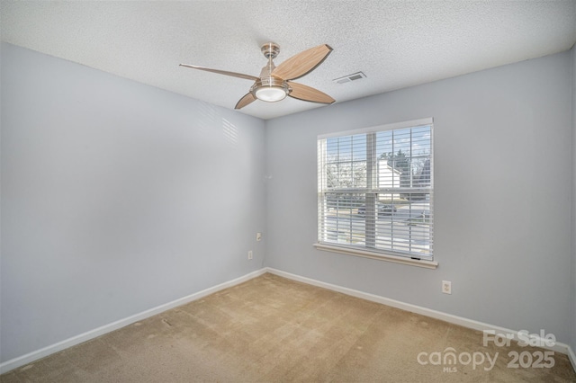 unfurnished room with visible vents, a ceiling fan, a textured ceiling, carpet, and baseboards