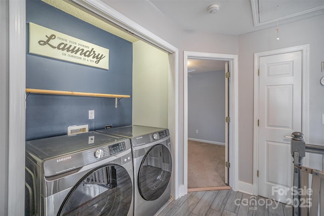 laundry room with independent washer and dryer, laundry area, baseboards, attic access, and wood tiled floor