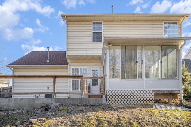 rear view of property featuring roof with shingles and a sunroom