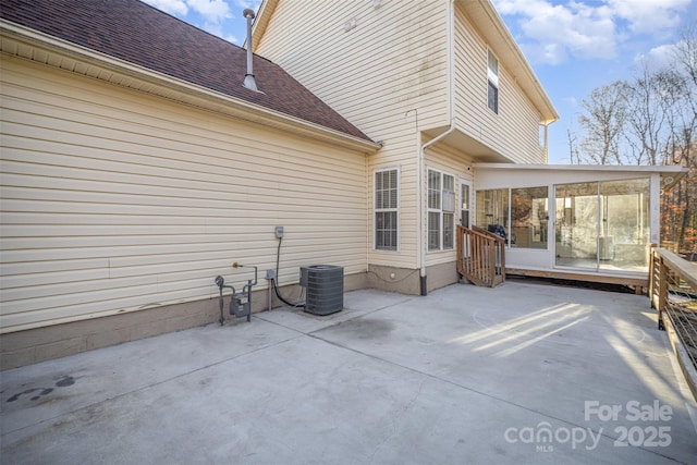 view of patio with cooling unit and a sunroom