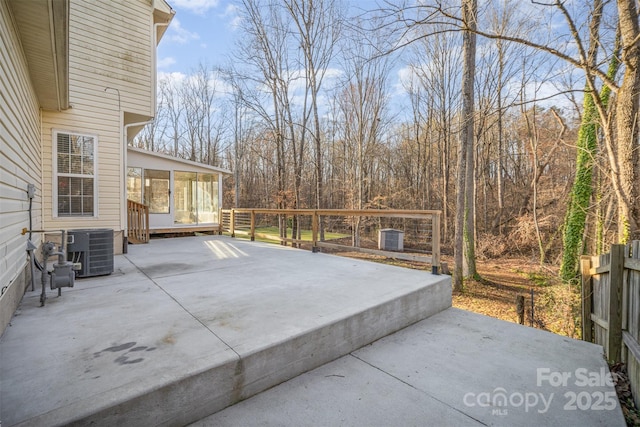 view of patio featuring fence, central AC, and a sunroom