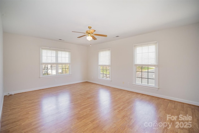 unfurnished room with light wood-style floors, baseboards, a ceiling fan, and visible vents