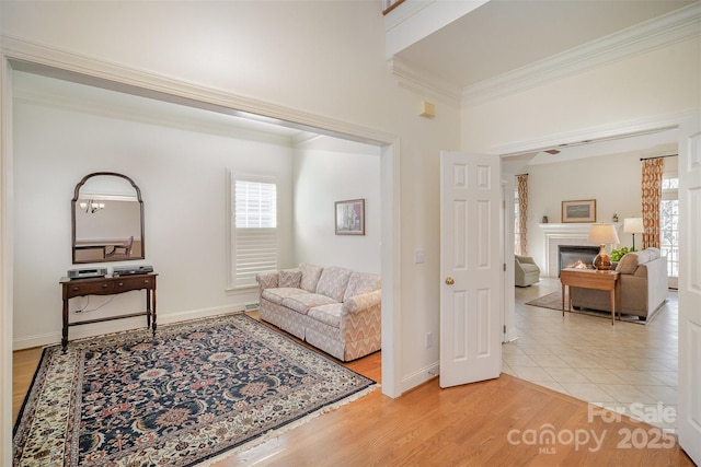 interior space featuring crown molding, baseboards, light wood-style floors, and a tile fireplace