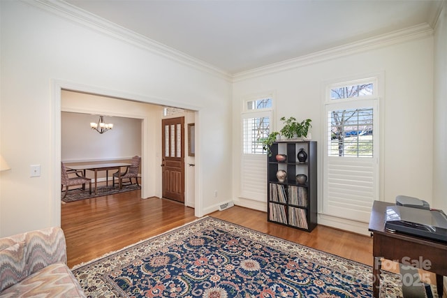 entryway featuring ornamental molding, wood finished floors, and a chandelier