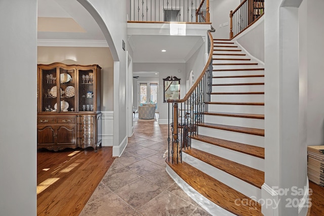 entrance foyer featuring stairway, wood finished floors, baseboards, and ornamental molding