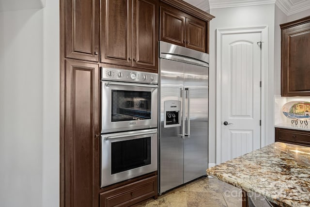 kitchen featuring decorative backsplash, crown molding, dark brown cabinetry, and stainless steel appliances