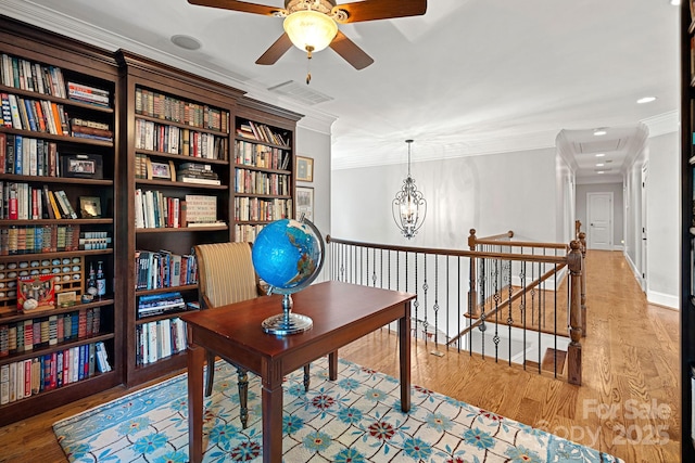 home office featuring an inviting chandelier, wood finished floors, visible vents, and ornamental molding