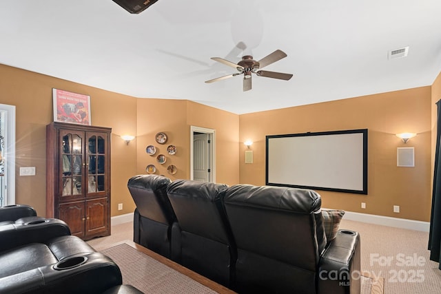 cinema room featuring light carpet, visible vents, ceiling fan, and baseboards