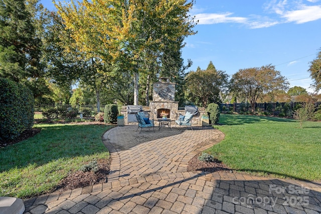 view of yard featuring a patio area, fence private yard, and an outdoor stone fireplace