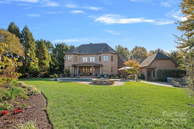 back of house featuring a patio, a yard, brick siding, and a pool with connected hot tub