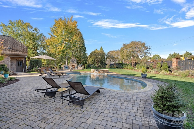 view of pool featuring a patio area, a lawn, a pool with connected hot tub, and fence