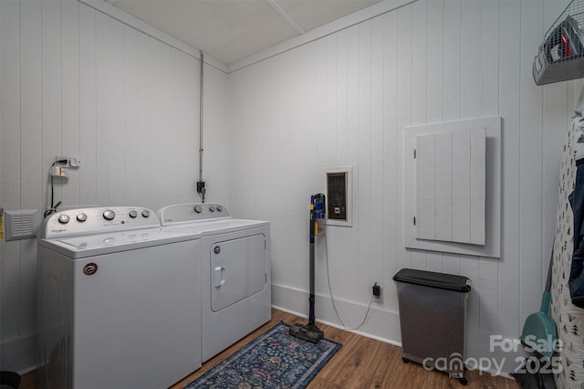 clothes washing area featuring laundry area, independent washer and dryer, and wood finished floors