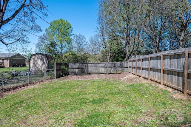 view of yard featuring a storage unit, an outdoor structure, and a fenced backyard