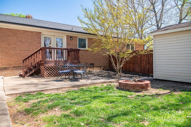 view of exterior entry featuring a patio, fence, french doors, crawl space, and brick siding