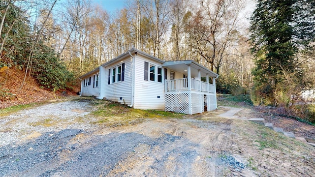 view of front of property with crawl space, a porch, and driveway