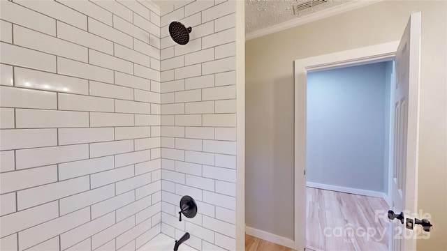 bathroom featuring visible vents, baseboards, shower / tub combination, wood finished floors, and a textured ceiling