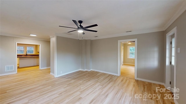 spare room featuring baseboards, wood finished floors, visible vents, and a sink