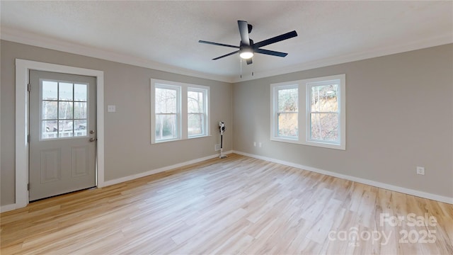 spare room with ceiling fan, baseboards, ornamental molding, wood finished floors, and a textured ceiling