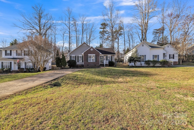 view of front of house featuring crawl space, driveway, brick siding, and a front lawn