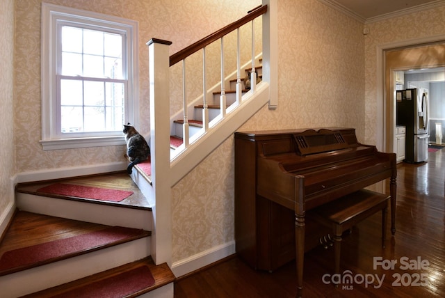 stairway with wallpapered walls, crown molding, baseboards, and wood finished floors