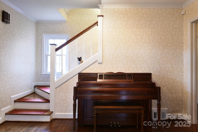 stairway with visible vents, wood finished floors, and wallpapered walls