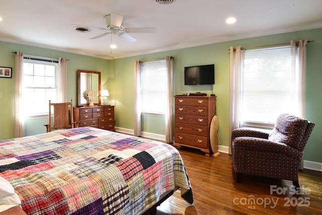 bedroom with visible vents, wood finished floors, baseboards, and ornamental molding