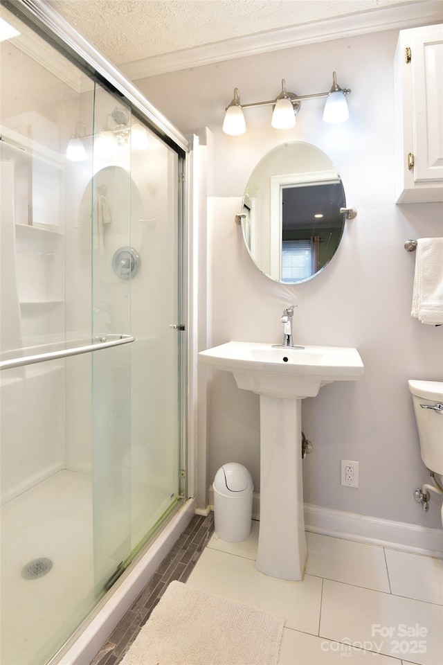 full bath with a shower stall, toilet, and a textured ceiling