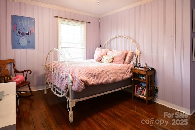 bedroom with ornamental molding, baseboards, and hardwood / wood-style floors