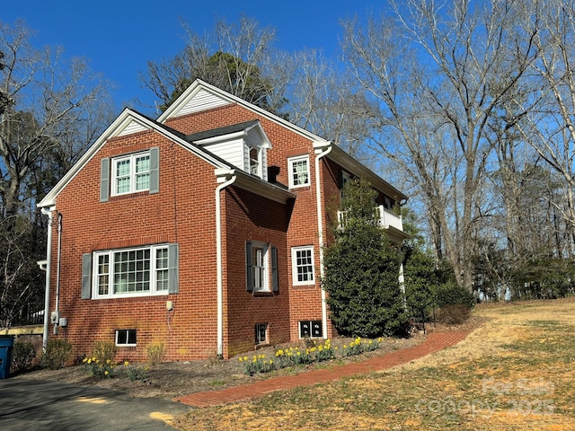 view of home's exterior with brick siding and a lawn