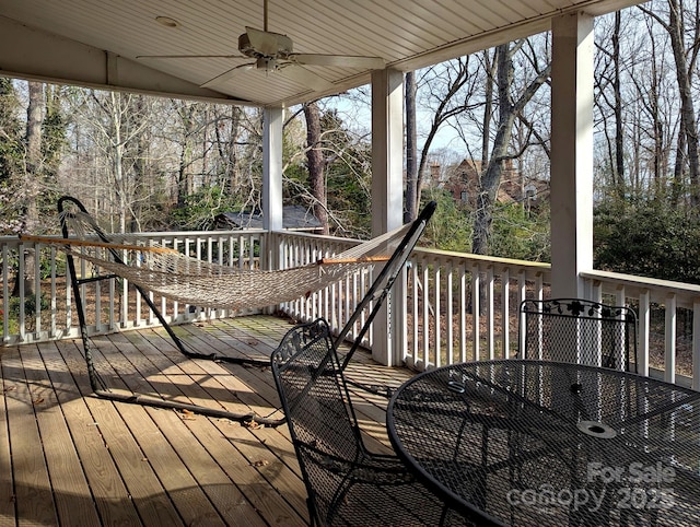 deck with outdoor dining space and a ceiling fan