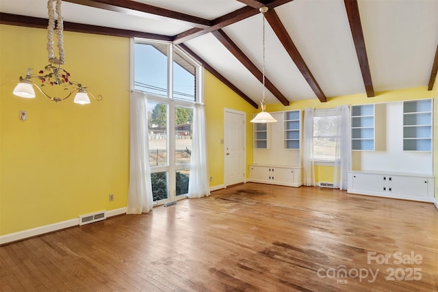 unfurnished living room with wood finished floors, visible vents, a wealth of natural light, and baseboards