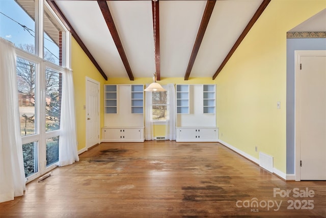 interior space with beamed ceiling, wood finished floors, visible vents, and baseboards