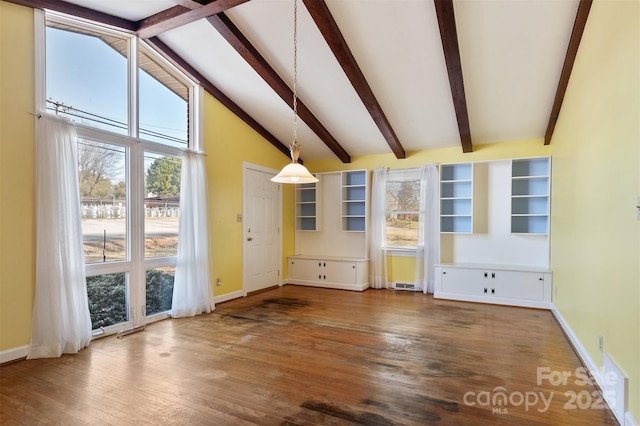 interior space with a wealth of natural light, beamed ceiling, baseboards, and wood finished floors