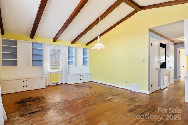 unfurnished living room featuring visible vents, baseboards, wood finished floors, and vaulted ceiling with beams