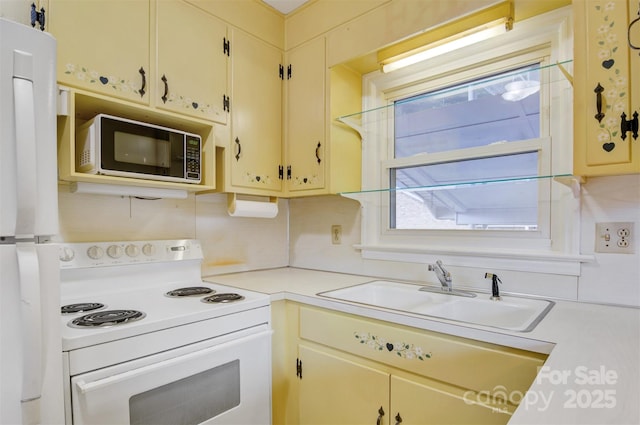 kitchen with light countertops, electric range, cream cabinets, and a sink