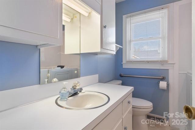 bathroom featuring toilet, washer / dryer, and vanity