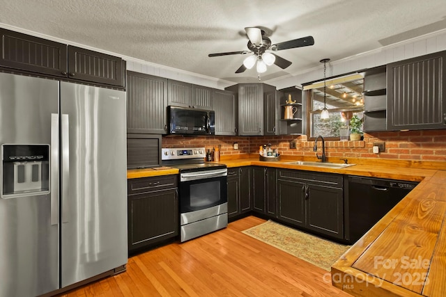 kitchen with a sink, butcher block counters, black appliances, and open shelves