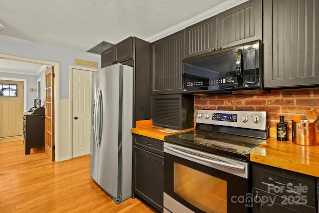 kitchen featuring wood counters, a textured ceiling, light wood finished floors, and stainless steel appliances