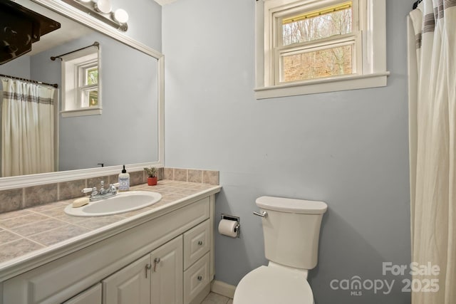 bathroom with toilet, plenty of natural light, and vanity