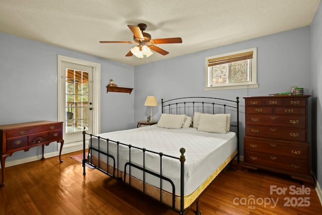 bedroom with a ceiling fan, wood finished floors, baseboards, a textured ceiling, and access to outside