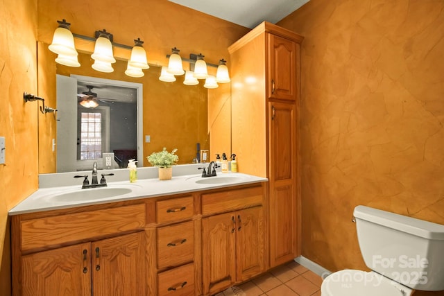 bathroom with tile patterned flooring, double vanity, toilet, and a sink