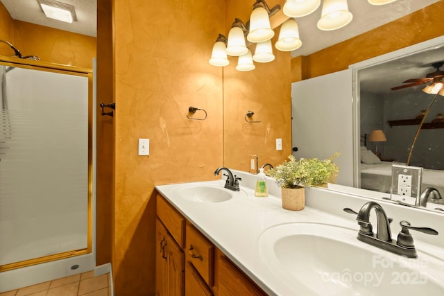 full bath with a ceiling fan, a shower stall, double vanity, and a sink