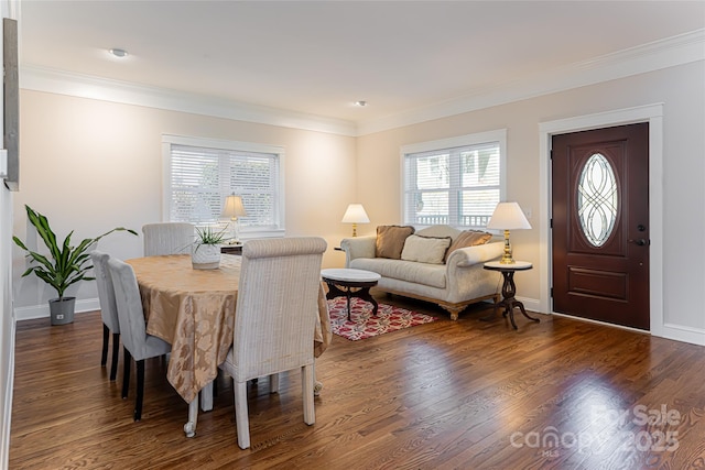 dining space featuring baseboards, wood finished floors, and ornamental molding