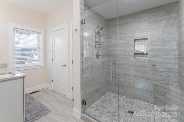 full bath with visible vents, baseboards, a stall shower, and vanity